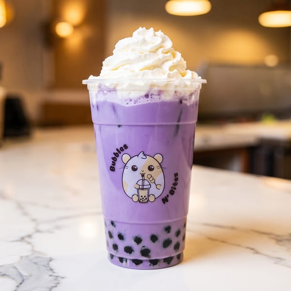 Purple taro bubble tea with whipped cream on a marble counter at Bubbles N' Bites.